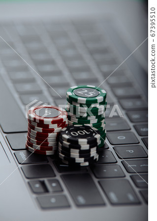 Stacks of poker chips on a laptop computer. Online casino concept Stacks of poker chips on a laptop computer. Online casino concept 67395510