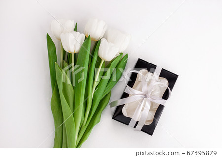 White tulip flowers and black gift box on light 67395879
