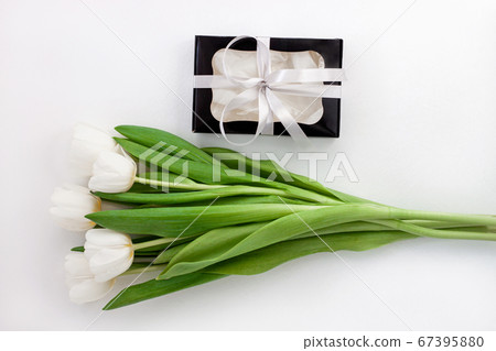 White tulip flowers and black gift box on light 67395880