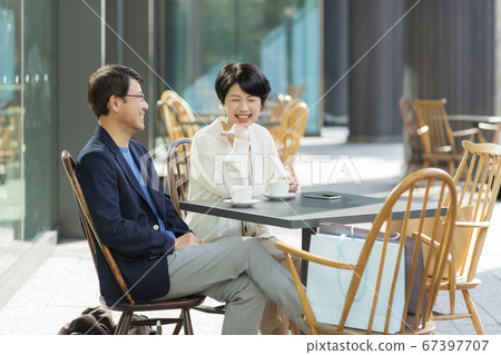Senior couple having a conversation on the terrace of the cafe Senior couple having a conversation on the terrace of the cafe 67397707