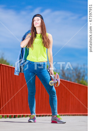 Teenage girl skater riding skateboard on street. 67397951
