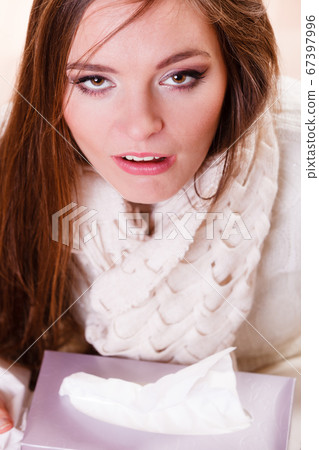 Sick woman girl with fever sneezing in tissue 67397996