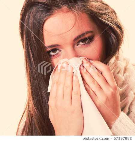 Sick woman girl with fever sneezing in tissue 67397998