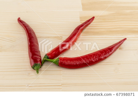 Long pods of hot red chili peppers spread out on a Long pods of hot red chili peppers spread out on a 67398071