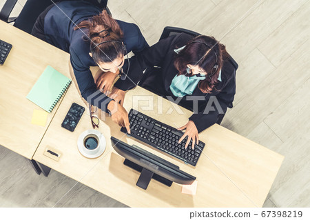 Business people wearing headset from top view in office working with computer Business people wearing headset from top view in office working with computer 67398219