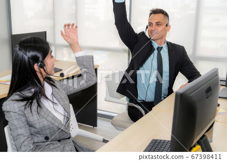 Business people wearing headset celebrate working in office Business people wearing headset celebrate working in office 67398411