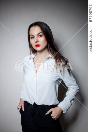Portrait of young woman with long black hair in business wear. Portrait of young woman with long black hair in business wear. 67398768