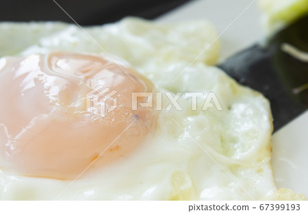 Fried Egg on Dish with Natural Light in Close Up View 67399193