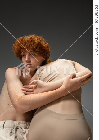 Portrait of beautiful redhead couple isolated on grey studio background. Concept of beauty, skin care, fashion and style Portrait of beautiful redhead couple isolated on grey studio background. Concept of beauty, skin care, fashion and style 67399553