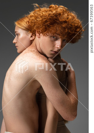 Portrait of beautiful redhead couple isolated on grey studio background. Concept of beauty, skin care, fashion and style Portrait of beautiful redhead couple isolated on grey studio background. Concept of beauty, skin care, fashion and style 67399563