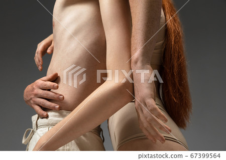 Portrait of beautiful redhead couple isolated on grey studio background. Concept of beauty, skin care, fashion and style Portrait of beautiful redhead couple isolated on grey studio background. Concept of beauty, skin care, fashion and style 67399564