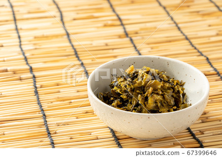 在一個小碗裡炒高良油。背景，百葉窗。 67399646