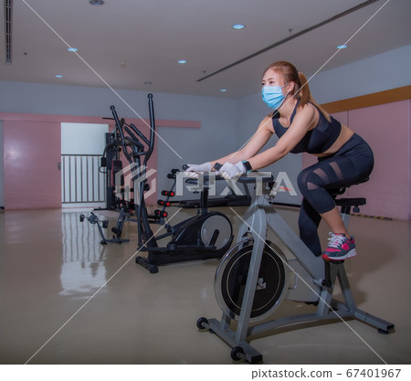 A sports girl is pushing up in a medical mask during a pandemic. COVID-19. Health care. A sports girl is pushing up in a medical mask during a pandemic. COVID-19. Health care. 67401967