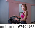 Full length profile shot of a young woman running on a treadmill in the gym. Young woman workout in gym healthy lifestyle.  67401968