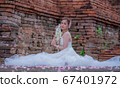 Thai young women portrait in Thai traditional dress at old temple, there is a garland in here hand, Chiangmai Thailand. 67401972