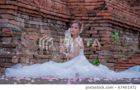 Thai young women portrait in Thai traditional dress at old temple, there is a garland in here hand, Chiangmai Thailand. Thai young women portrait in Thai traditional dress at old temple, there is a garland in here hand, Chiangmai Thailand. 67401972