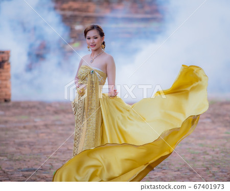 Woman wearing typical thai dress with thai style, Beauty fantasy Thai dress traditional costume on brick in old temple Woman wearing typical thai dress with thai style, Beauty fantasy Thai dress traditional costume on brick in old temple 67401973