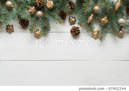 Christmas white frame of golden baubles and evegreen fir tree on wooden board. Top view. 67402244