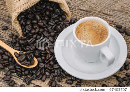 Coffee cup and coffee beans roasted in a sack on a Coffee cup and coffee beans roasted in a sack on a 67403797