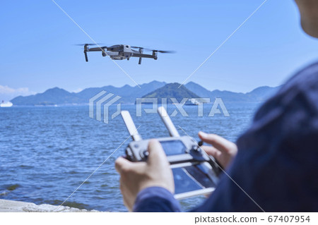 Hand of a Japanese man operating a drone 67407954