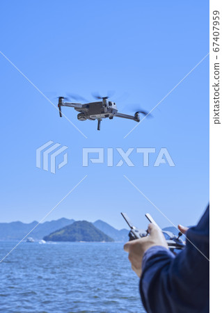Hand of a Japanese man operating a drone 67407959