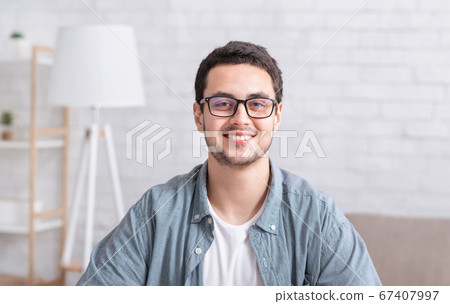 Young businessman working at home. Guy with glasses in interior 67407997