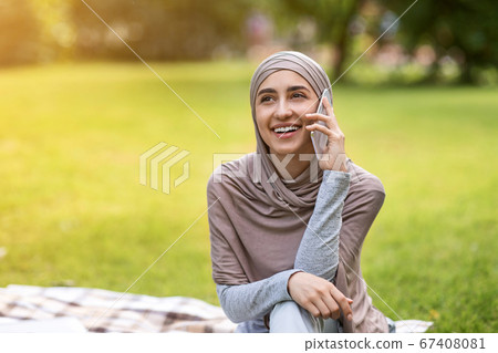 Girl in headscarf resting alone in public park Girl in headscarf resting alone in public park 67408081