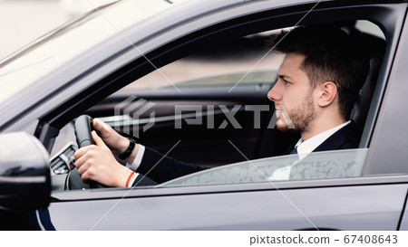 Focused business man driving alone in his new car Focused business man driving alone in his new car 67408643