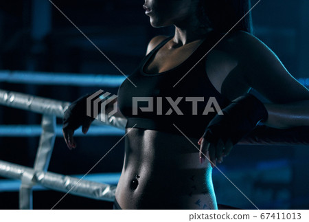 Female fighter posing near ring. 67411013