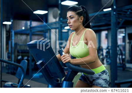 Fitness woman doing cardio in gym. Fitness woman doing cardio in gym. 67411021