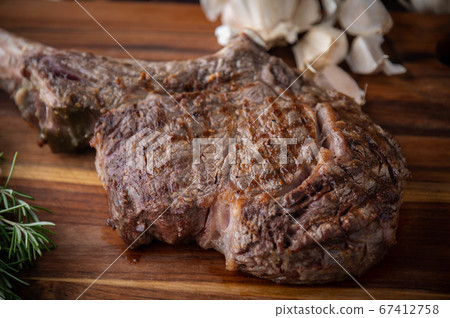 grilled tomahawk steak on wooden board grilled tomahawk steak on wooden board 67412758