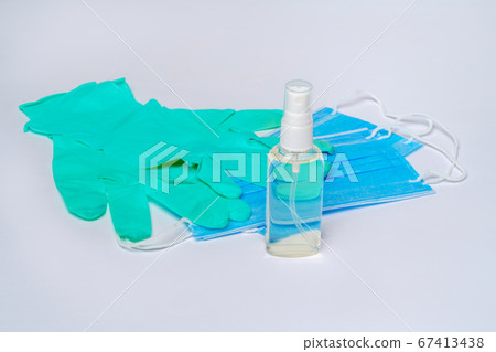 bottle of lotion, sanitizer or liquid soap and protective mask over light grey background 67413438