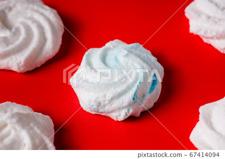 Homemade sweet colored meringue on red background. Homemade sweet colored meringue on red background. 67414094