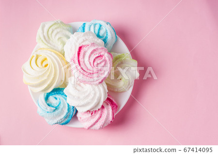 Homemade sweet colored meringue on pink 67414095