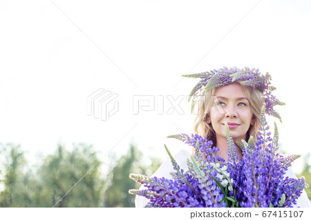 A beautiful, happy girl enjoying a lupine field in A beautiful, happy girl enjoying a lupine field in 67415107