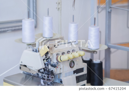 Tailor, fashion designer workplace - overlocking sewing machine on table Tailor, fashion designer workplace - overlocking sewing machine on table 67415204