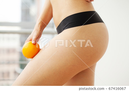 Woman showing a perfect skin with an orange Woman showing a perfect skin with an orange 67416067