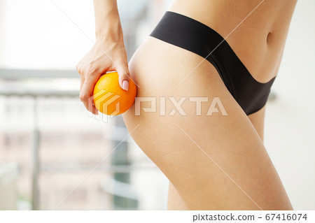 Woman showing a perfect skin with an orange Woman showing a perfect skin with an orange 67416074