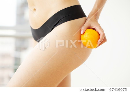 Woman showing a perfect skin with an orange 67416075
