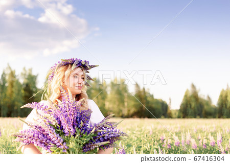 A beautiful, happy girl enjoying a lupine field in A beautiful, happy girl enjoying a lupine field in 67416304