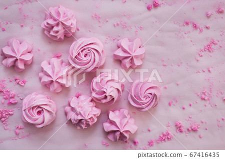 Pink meringues on plate, colorful background Pink meringues on plate, colorful background 67416435