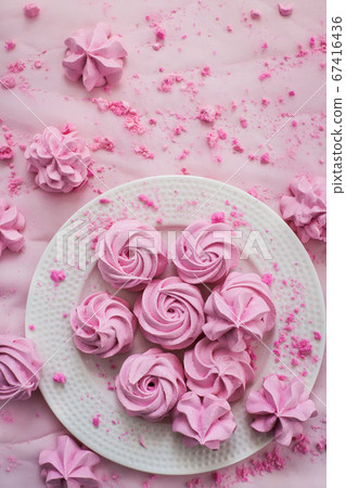 Pink meringues on plate, colorful background Pink meringues on plate, colorful background 67416436