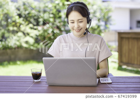 年輕女子在花園裡做遠程辦公 67419399