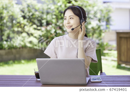 年輕女子在花園裡做遠程辦公 67419401