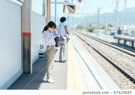 Woman looking at bag at station platform 67420685