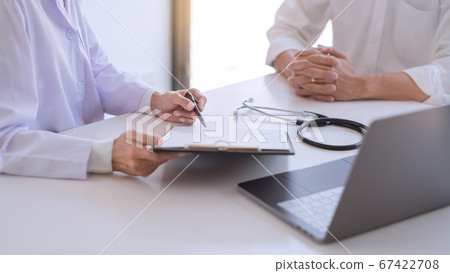 Doctor and patient consults or discussing about 67422708