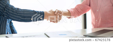 Two confident business man shaking hands during a Two confident business man shaking hands during a 67423178