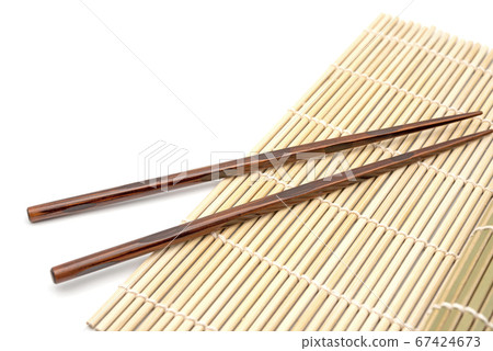Chopsticks on black bamboo mat, high angle, background 67424673