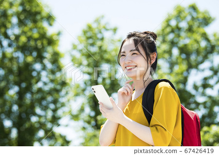A young woman operating a smartphone A young woman operating a smartphone 67426419