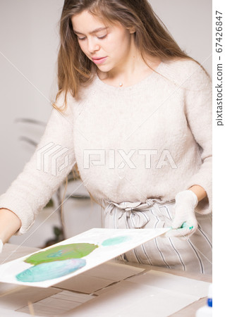 The girl creates a picture with abstraction in bright colors. The girl creates a picture with abstraction in bright colors. 67426847